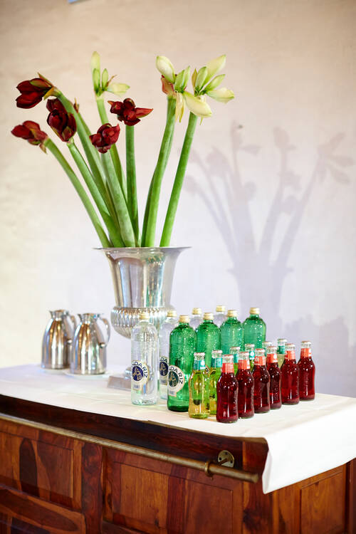 Ein eleganter Getränketisch mit Blumenarrangement – stilvolle Pausenverpflegung im Tagungshotel Mecklenburg Vorpommern.