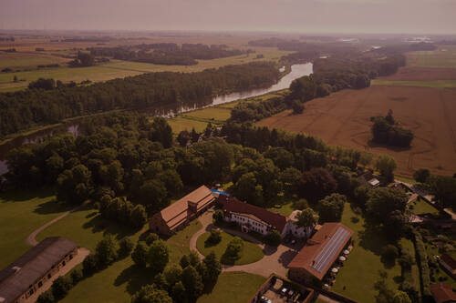 Eine Luftaufnahme des Gutshaus Stolpe an der Peene – idyllische Lage und Rückzugsort für konzentriertes Arbeiten im Tagungshotel Mecklenburg Vorpommern.