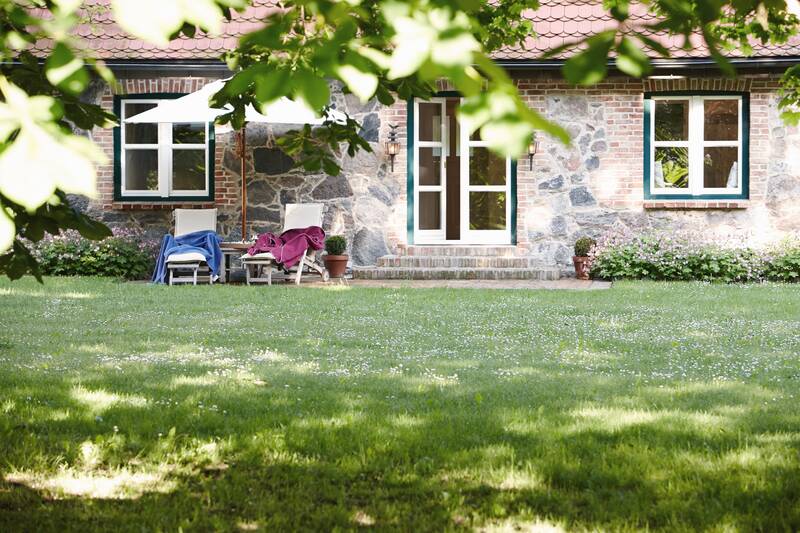 Ein gemütliches Steinhaus mit Liegestühlen und Sonnenschirm im gepflegten Garten.Ein gemütliches Steinhaus mit Liegestühlen und Sonnenschirm im gepflegten Garten.