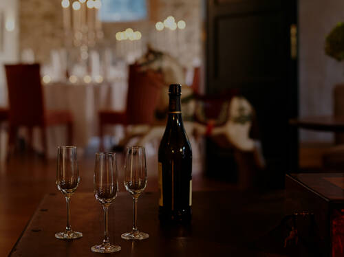 Ein Tisch mit Wein und Gläsern im Kerzenschein – romantisches Ambiente in einem Restaurant in Stolpe an der Peene.