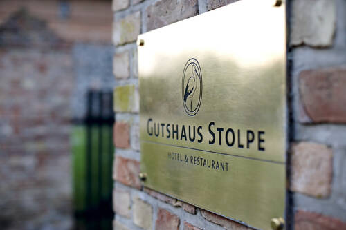 Ein Messingschild am Eingang des Gutshaus Stolpe – Idealer Urlaubsort für einen Wochenendtrip ab Hamburg oder Berlin in stilvollem Ambiente.