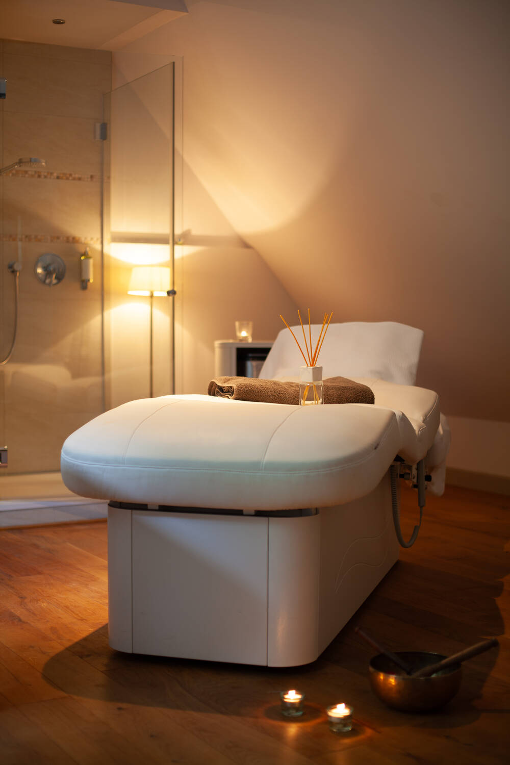 Ein Massageraum mit Kerzenlicht und warmem Holz – tiefe Entspannung und Achtsamkeit im Wellnesshotel Mecklenburg Vorpommern.
