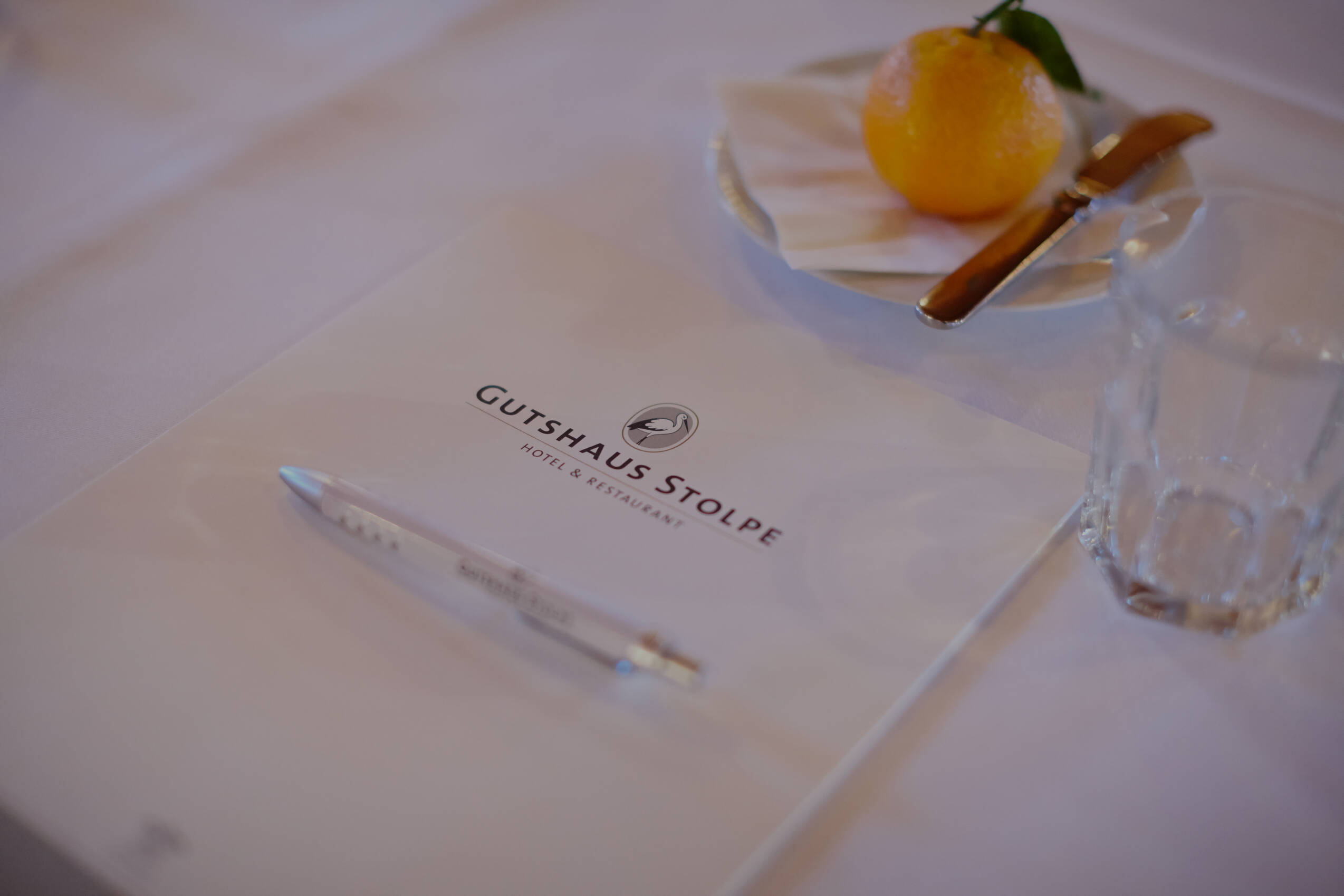 Eine Schreibunterlage und Stift mit Gutshaus-Logo – sorgfältig vorbereitet für produktive Meetings im Tagungshotel Mecklenburg Vorpommern.
