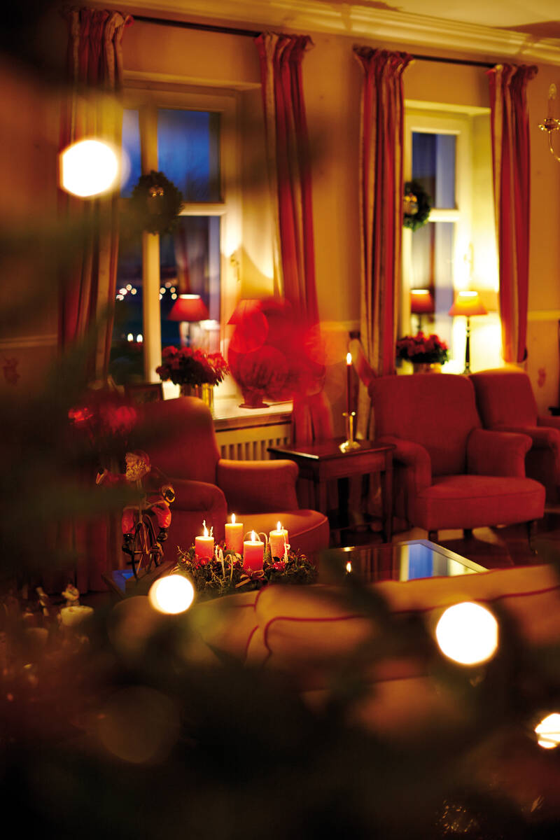 Warmer Kerzenschein und festlicher Glanz – besinnliche Stimmung im romantischen Hotel Norddeutschland zur Winterzeit.