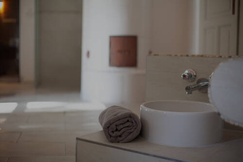 Ein modernes Bad mit einem Handtuch und Waschbecken im Wellnesshotel Gutshaus Stolpe.