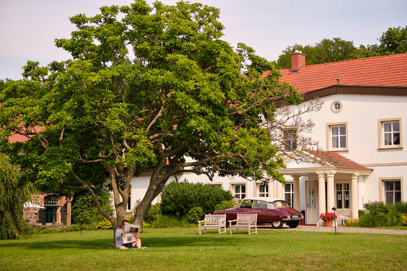 Das Gutshaus Stolpe im Sommer – umgeben von Natur, alten Bäumen und Ruhe, ein wahrhaft romantisches Hotel Norddeutschland.